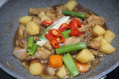 Sau đó cho gà vào chảo, thêm vào 500ml nước dùng gà, 7 muỗng canh nước tương, đường, bột cà phê, tỏi băm, gừng băm. Đun cho nước cạn bớt rồi cho vào hành tây, cà rốt thái nhỏ, dầu mè, tiêu vào đun tiếp cho rau củ chín. Sau đó thêm ít lá hành boa rô và ớt thái nhỏ tắt bếp.