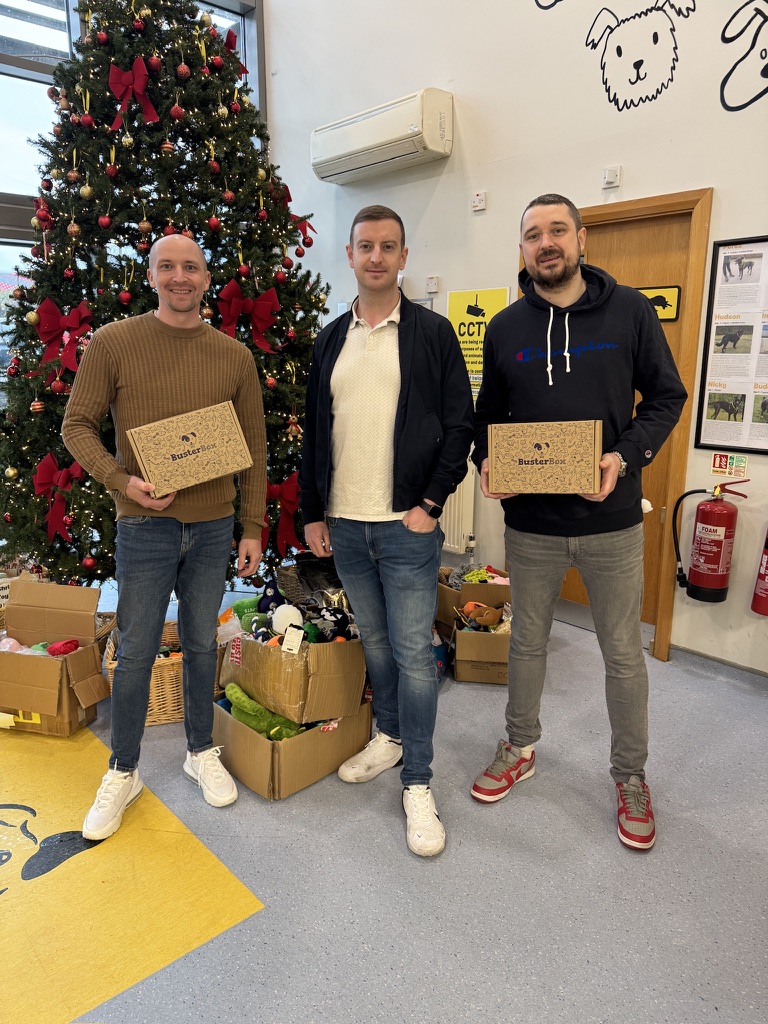 Three members of the Top Dog team carrying donation boxes