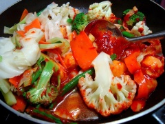 Tiếp đến cho phần rau củ và cá viên vào đảo đều. Nêm lại với một chút gia vị. Tiếp tục xào trên lửa lớn cho phần tương ớt sệt lại như mong muốn, nếu chúng ta xào lửa nhỏ thì rau cải rất dễ bị quá chín ăn sẽ mất độ giòn. Lúc đó chúng ta sẽ cho đậu đã rán sơ vào.