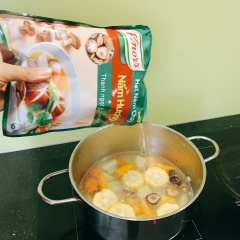 Cho nồi lên bếp với 1 thìa dầu, đun nóng thì cho thêm hành khô vào phi thơm. Sau đó cho cà rốt, nấm hương, ngô ngọt, su hào, bí đỏ vào đảo xào vài lượt rồi thêm nước vào đun sôi, thêm 1 thìa bột canh và đun sôi lửa vừa để các nguyên liệu chín mềm.