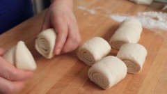 Tạo hình bánh bao Hàn Quốc: Phủ lên thớt và khối bột 2 muỗng bột mì khô. Đặt khối bột lên, dùng chày cán thành miếng bột mỏng kích cỡ chiều rộng khoảng 33cm, chiều sâu khỏng 35cm. Phết một lớp dầu ăn lên miếng bột, rắc 2 muỗng đường trắng lên cho đều khắp. Cuốn bột lại thành cuộn và lấy dao cắt thành khoảng 7 - 8 khúc bột.