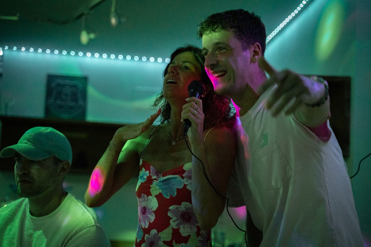 Two guests singing karaoke under coloured lights