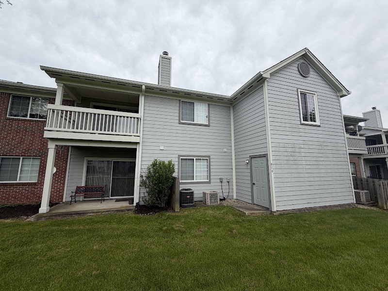 Rear of a Hidden Creek Condominiums building before the project, white siding and balcony