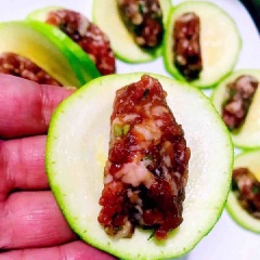 Múc 1 muỗng nhỏ nhân thịt băm, vê thành kén rồi cho vào 1 lát bí, uốn cong lại. xếp ra đĩa. Làm tương tự cho hết nguyên liệu. Đập 1 quả trứng cho vào giữa đĩa.