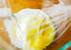 Đầu tiên, trộn đều bột mì, bột nở. Trong một tô khác, đánh đều trứng gà với sữa tươi không đường, sữa chua.