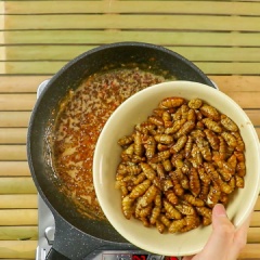 Bắc chảo nóng cho 30gr bơ thực vật vào cùng hỗn hợp tỏi ớt vào xào thơm, cho tiếp 3 muỗng canh nước mắm, 10ml nước lọc. Nấu 5 phút rồi cho phần nhộng chiên vào xào đều trong 3 phút rồi tắt bếp.