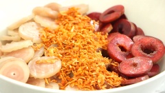 Bắt đầu trộn thôi nào: cho mận và da heo vào tô, thêm 30gr tép khô, 10gr ớt khô, 10gr rau răm cắt nhỏ, rưới nước mắm lên rồi trộn đều.
