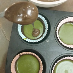 Sau khi lớp bơ hạnh nhân đã đông, lấy ra đổ chocolate phủ kín mặt nhân, sau đó để tủ lạnh cho đông lại hoàn toàn.