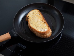 Bắc chảo không dính lên bếp, rưới dầu olive vào đun nóng rồi láng đều dầu khắp mặt chảo, thả bánh mì vào chiên áp chảo trong khoảng 3 phút, sau đó trở mặt khác và chiên thêm 3 phút nữa.