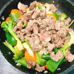 Cho cà rốt, bông cải xanh-trắng, ớt chuông vào chảo, đậy nắp 3 phút. Cho thịt bò vào chảo trộn đều.