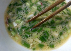 Hành lá và ớt rửa sạch, cắt khúc ngắn. Cho trứng gà, hành lá, ớt vào chén, đánh đều.