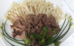 Cho thịt bò, nấm kim châm đã xào ra đĩa. Trang trí thêm bông hẹ, ngò rí nếu thích nhé!