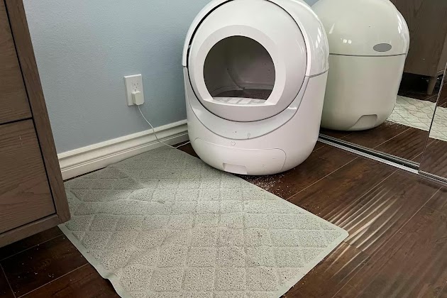 La alfombrilla atrapa arena para gatos Gorilla Grip delante de una caja de arena