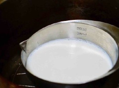 Tiếp đó cho 2 muỗng canh đường, 250ml sữa tươi vào nồi khuấy cho đến khi đường tan hoàn toàn. Đổ 1/2 phần gelatine vào chỗ sữa tươi rồi khấy đều.