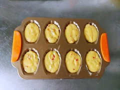Thêm kiwi xắt nhỏ và cà chua khô vào tô bột làm bánh sò, và sử dụng phới dẹp để trộn cho quyện đều là được. Cho hỗn hợp làm bánh sò vào đầy 2/3 các khuôn bánh sò. Làm nóng trước lò nướng ở 170 độ C. Đặt khay bánh sò nướng trong lò khoảng 15 phút là bánh chín nhé.
