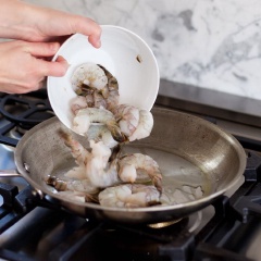 Tôm rửa sạch, lột vỏ và đầu, bỏ chỉ đen ở thân tôm. Khi làm tôm nhớ giữ lại phần đuôi để trang trí cho đẹp nhé. Bắc 1 cái chảo lên bếp, cho dầu olive vào đun nóng rồi cho tôm vào.