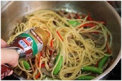 Sau đó cho mì đã luộc chín vào, rắc 1/4 muỗng cà phê tiêu, 1/2 muỗng cà phê nước tương, xào đều tay rồi nêm nếm lại cho vừa ăn.
