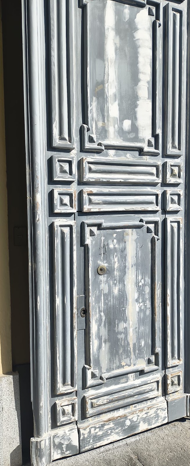 Portone in legno durante la sverniciatura e la stuccatura sul posto