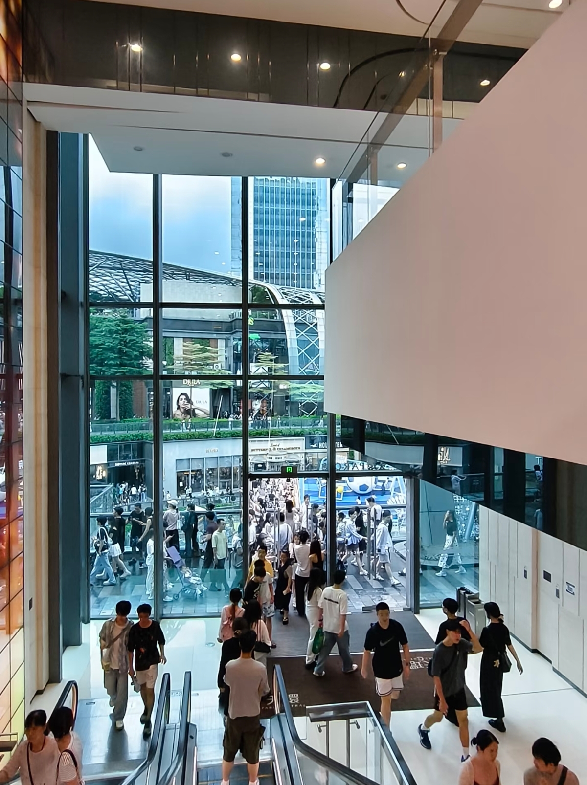 Interior atrium of Taikoo Hui mall with luxury and sportswear retail stores
