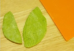 Tiếp theo các ấy cán mỏng thành hình chiếc lá và khía các đường thẳng trông giống bẹ bắp. Bọc 2 lá 2 bên bột mì vừa làm hình trái bắp. Cuối cùng chúng mình cho vào lò nướng khoảng 15-20 phút ở 220 độ C.