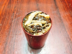 Đun nóng 1 muỗng canh dầu ăn, cho hành tím băm vào phi cho thơm rồi đổ phần tai heo, lưỡi heo đã ướp gia vị vào xào. Đảo đều và xào cho nguyên liệu chín. Khi thấy thịt hơi xém cạnh và phần mỡ bắt đầu chảy ra thì cho nấm mèo vào xào thêm 2 phút nữa cho nấm chín, bạn có thể nêm nếm lại cho vừa khẩu vị là tắt bếp, rắc thêm chút tiêu cho món ăn dậy mùi thơm. Xúc nguyên liệu vừa xào vào khuôn rồi ép chặt, dùng muỗng gỗ ấn đều sau đó bạn có thể dùng dụng cụ để đè lên trên cho giò thủ được chặt.
