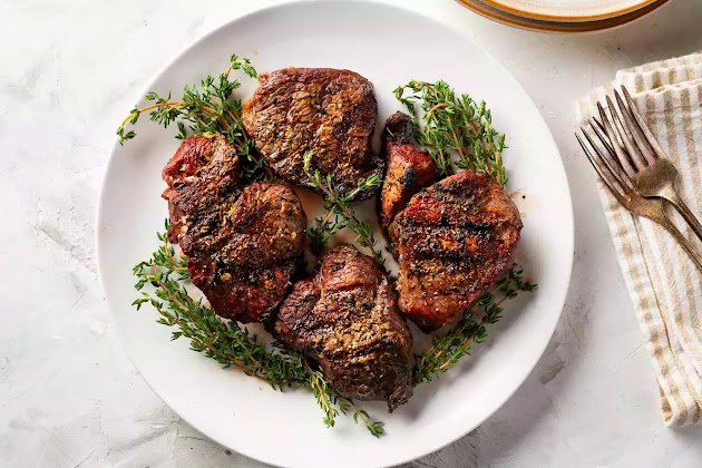 Filetto mignon con crosta di erbe aromatiche su un piatto bianco
