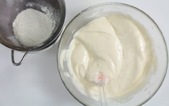 Rây 50g bột mì vào hỗn hợp rồi dùng phới trộn cho quyện đều. Sau đó rây tiếp lượng bột còn lại vào hỗn hợp rồi trộn đều lên.