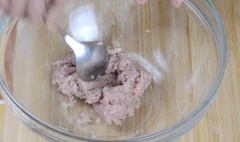 Bắt đầu bằng cách thêm 2 tép tỏi và 1/2 muỗng canh thân ngò rí vào cối, giã nhuyễn. Sau đó, múc 1 nửa hỗn hợp giã cho vào tô trộn cùng với một chút tiêu xay, 125g thịt băm nhỏ và 1/2 muỗng canh nước mắm, nhồi cho quyện đều, đặt vào ngăn mát tủ lạnh 1 tiếng đồng hồ.