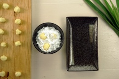 Áo bột lần 1: Chuẩn bị dĩa đựng phô mai viên. Nhanh chóng lăn phô mai viên đường qua chén bột năng, đặt qua dĩa đã chuẩn bị. Để yên phô mai khoảng 3-5 phút, lúc này cái lạnh và đường của phô mai đã thấm nhanh lớp bột mới vừa áo.
