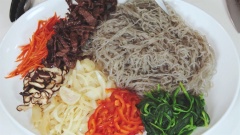 Cho 75ml nước tương Hàn Quốc, 60g đường, 10g vừng trắng, 30ml dầu mè, 1 chén tỏi băm, hạt tiêu đen vào tô, trộn đều để làm nước sốt trộn miến. Xếp tất cả nguyên liệu đã chế biến ra đĩa to.