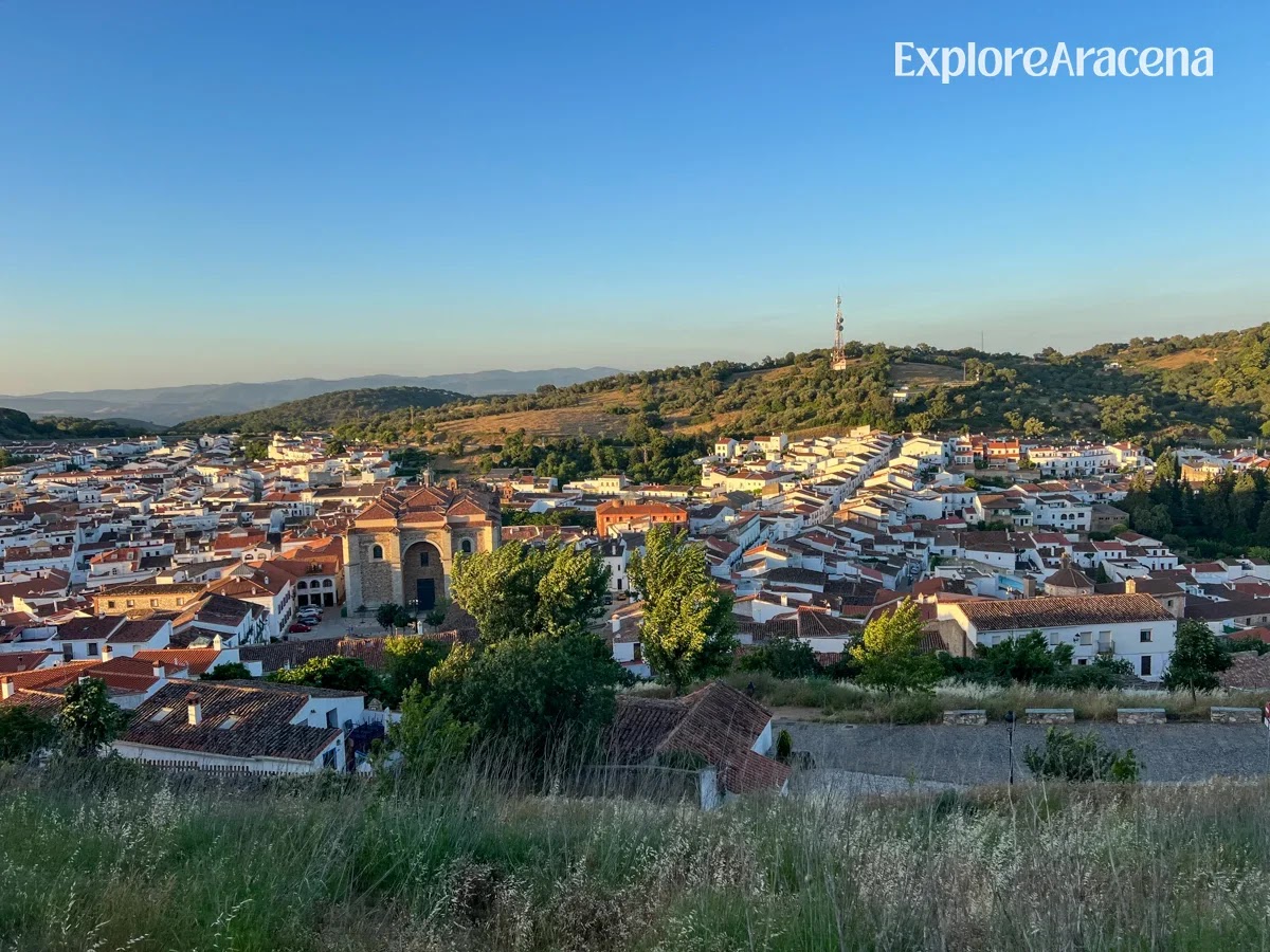 Golden hour view over the white houses of Aracena from the path leading to the castle.