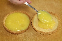 Sau đó, đổ phần hỗn hợp chanh trứng xuống đáy bánh tart. Xếp dâu tây lên trên rồi phết mứt lên dâu tây.
