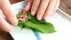 Rửa lá lốt thật sạch và nhẹ nhàng, tránh làm rách lá lốt bạn nhé, vì mình cuốn trực tiếp thịt bò vào lá lốt cần được làm sạch, không còn dính bẩn. Để lá lốt thật khô ráo thì mới cuốn thịt được nha. Trải lá lốt lên dĩa, múc một muỗng thịt bò lên lá, lấy tay gắp hai bên mép lá lại, cuốn tròn cho đến hết lá. Cuốn thịt như vậy đến khi hết nguyên liệu. Xiên từng cuốn bò vào cây xiên.