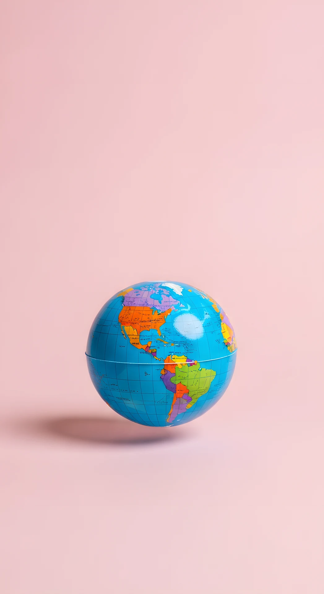Bright Studio Shot of a Small Colorful World Globe on a Solid Pastel Pink Background - Free 4K mobile Wallpaper