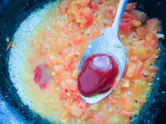 Xào cà chua thêm chút nước, dùng muỗng dằm nát miếng cà chua, thêm vào 1 muỗng canh tương cà. Đun với lửa nhỏ đến khi nước sệt lại là được.