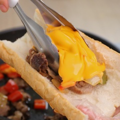 Chuẩn bị 2 khúc bánh mì Baguette (có thể để vào lò nướng 30 giây để bánh mỳ giòn hơn), dùng dao cắt dọc bên cạnh ổ, cho một phần bò vào bánh mỳ, đã có thể thưởng thức ngay rồi. Bánh mì thì giòn rụm bên ngoài, kẹp bên trong thịt ba chỉ bò vừa ngọt mềm, hòa quyện với các loại rau củ thanh mát, được phủ lên trên lớp phô mai Mỹ béo ngậy, mang đến cho bạn những trải nghiệm mới mẻ cho bữa sáng đầy năng lượng.