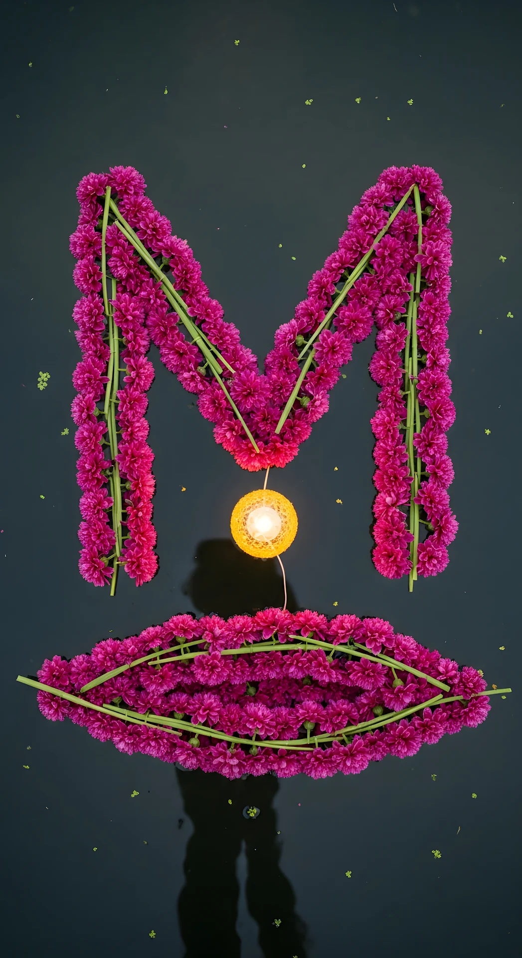 Magenta Flower Letter M and Glowing Diya on Dark Water - Free 4K mobile Wallpaper