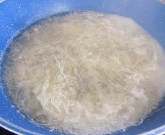 Nấu 1 lít nước cùng với 1 muỗng canh nước mắm và 1/3 muỗng cà phê muối. Khi nước sôi cho thịt băm vào luộc chín, vớt thịt luộc ra, cho vào âu. Vẫn nồi nước luộc thịt đang sôi. Cho miến vào luộc nhanh cho đến khi thấy sợi miến trong là đã chín. Vớt miến ra cho vào âu thịt luộc.