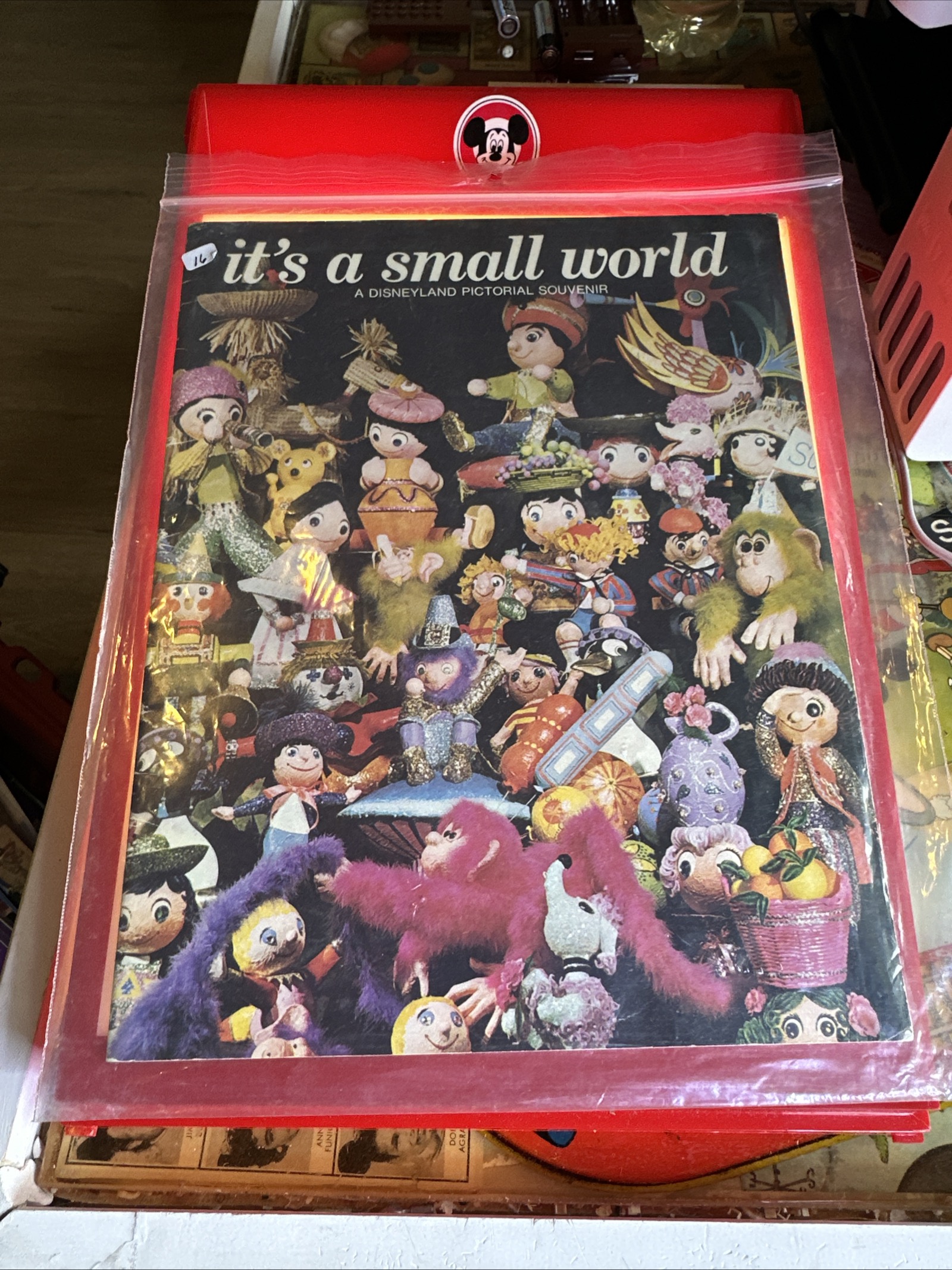 Large format Disneyland souvenir book for it's a small world, 9 by 12 inches, featuring full-color cover photography of the attraction's exterior with topiary animals, circa late 1960s