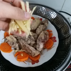 Mở nắp nồi, tiếp tục cho 1 muỗng cf nước tương vào gà để thịt gà thơm ơn. Sau đó, cho cà rốt vào nồi hấp cùng với gà. Gừng: cạo sạch vỏ, rửa sạch và cắt sợi nhuyễn, cho vào nồi gà đang hấp. Đậy nắp lại, hấp thêm 7' nữa.