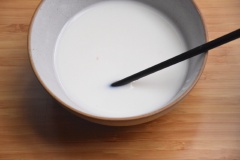 Thêm 35g đường trắng vào tô sữa tươi, rây 160g bột mì vào, khuấy cho quyện đều.