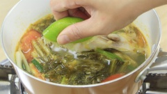 Khi cá chín, cho hỗn hợp dưa cải chua vào nồi nước luộc cá. Nêm thêm 1 muỗng canh hạt nêm và 1 muỗng canh nước cốt chanh. Khuấy đều và tắt bếp.