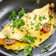 Cà chua bị rửa sạch, thái đôi, cho cà chua, phô mai vào 1/2 mặt trứng. Rắc khoảng 1/2 lượng ngò tây băm vào. Dùng sạn lật mặt còn lại của trứng và gập lại. Tắt lửa. Lúc này bạn có thể rắc ngò tây băm hoặc hành lá băm tùy thích nữa nha.