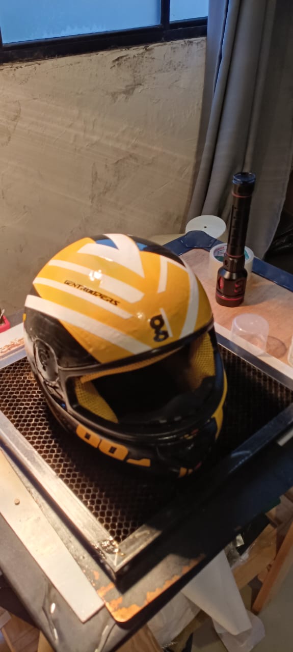 Ângulo superior do capacete Gentroopers customizado, destacando os adesivos brancos e pretos sobre o fundo amarelo.