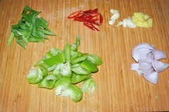 Sườn heo mua về làm sạch, rửa nhiều lần với muối và nước để không còn mùi hôi của thịt, để ráo nước. Chặt sườn thành từng miếng vừa ăn. Cho sườn vào tô ướp với 1 muỗng rượu gạo, 1 muỗng muối, 1 muỗng tiêu, 1 muỗng bột bắp, 1 muỗng nước tương và để 30 phút cho thấm gia vị. Ớt chuông rửa sạch, bỏ hạt, xắt miếng vừa ăn. Hành, tỏi lột vỏ, xắt nhỏ. Ớt đỏ xắt lát. Hành lá cắt khúc.