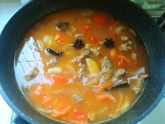 Xào cà chua hơi mềm thì thêm thịt bò, xào đều. Thêm 2 muỗng canh nước tương, 1 muỗng canh dầu hào và xào đều, thêm lượng nước thích hợp (khoảng 1.5 lít).