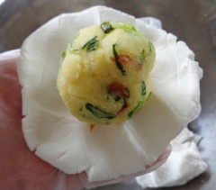 Chia bột ra những phần nhỏ có kích thước gắp đôi mỗi viên nhân. Viên tròn bột rồi ấm dẹp, cho nhân đậu vào, viên tròn lại, để vỏ bánh bọc kín nhân. Ấn cho bánh hơi dẹp.