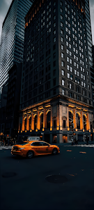 Yellow Taxi Passing Historic Building at Twilight