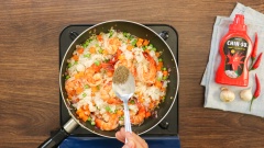 Bắc chảo lên bếp, cho vào 2 muỗng canh dầu ăn, chờ dầu nóng rồi phi thơm 10gr tỏi băm và 20gr hành tây tím. Cho 300gr tôm vào đảo đều đến khi tôm gần chín thì cho vào 50gr đậu Hà Lan và 50gr cà rốt, sau đó cho 400gr cơm nguội, đảo cho cơm tơi. Nêm gia vị với 1/2 muỗng cà phê tiêu, 1 muỗng canh nước mắm, 1/2 muỗng cà phê hạt nêm rồi đảo đều khoảng 10 phút.