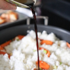 Kế tiếp cho tỏi băm, đầu hành lá vào xào thơm. Trút cơm vào rang khoảng 2 phút thì bạn rưới nước tương và đập trứng gà vào, đảo đều. Rang cho đến khi hạt cơm phủ đều trứng và khô ráo từng hạt.
